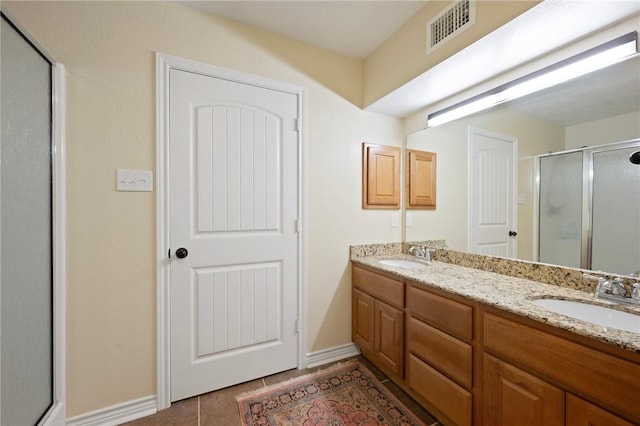 full bath featuring visible vents, a stall shower, double vanity, and a sink