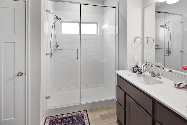 bathroom featuring hardwood / wood-style flooring, vanity, and walk in shower