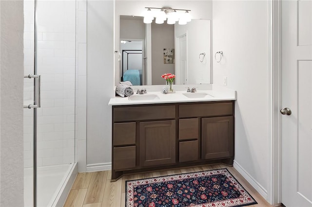 bathroom with hardwood / wood-style floors, vanity, and walk in shower