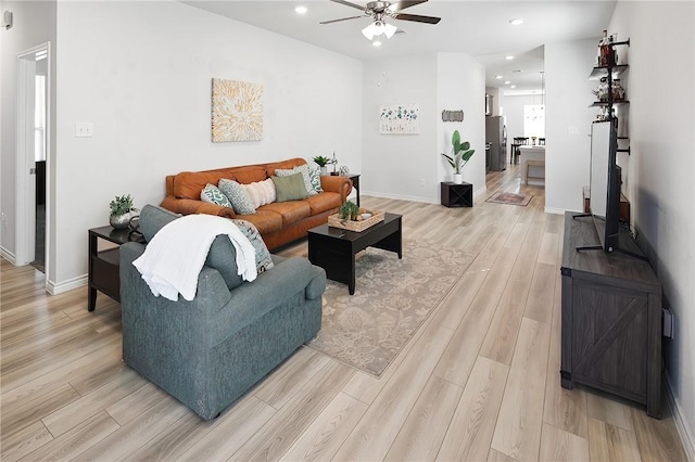 living room with light wood-type flooring and ceiling fan