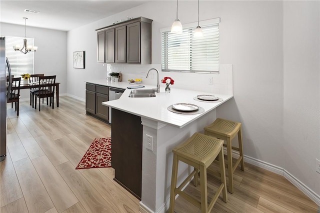 kitchen featuring light hardwood / wood-style flooring, sink, hanging light fixtures, and a kitchen bar