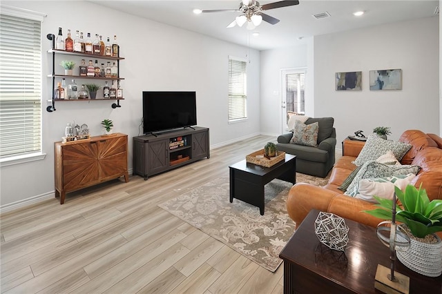 living room featuring light wood-type flooring and ceiling fan