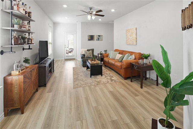 living room with ceiling fan and light wood-type flooring