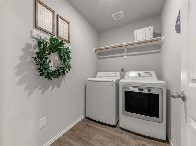 2412 Divot Ln, Navasota, TX 77868 - laundry room with washer and clothes dryer, wood finished floors, and baseboards