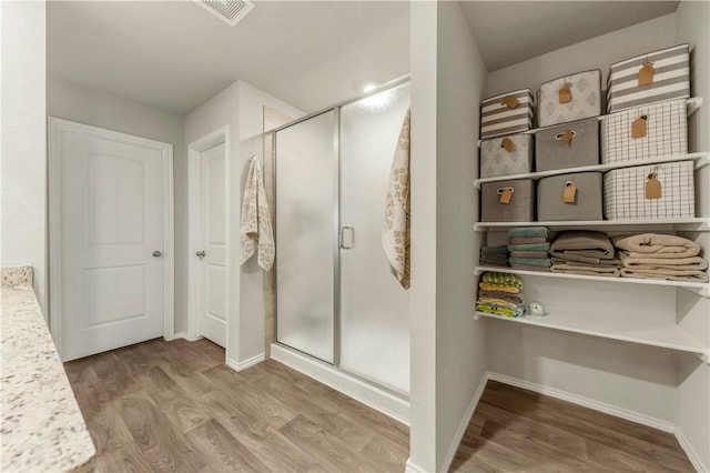 2412 Divot Ln, Navasota, TX 77868 - full bath featuring wood finished floors, a shower stall, and baseboards