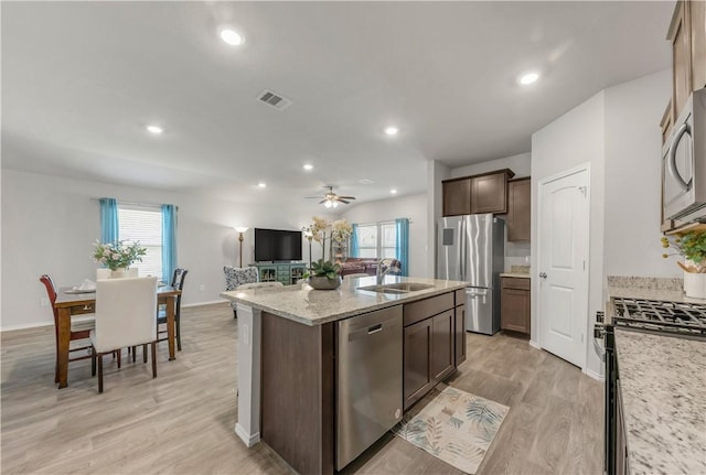 2412 Divot Ln, Navasota, TX 77868 - kitchen with stainless steel appliances, a center island with sink, open floor plan, plenty of natural light, and recessed lighting