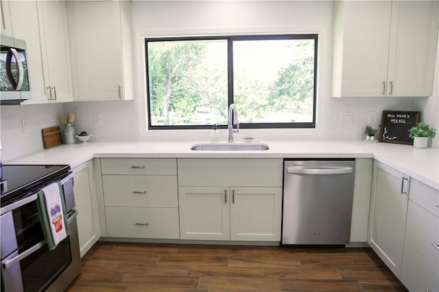 kitchen featuring sink, white cabinets, appliances with stainless steel finishes, and dark hardwood / wood-style flooring