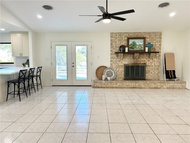 tiled living room with a brick fireplace, a wealth of natural light, french doors, and vaulted ceiling