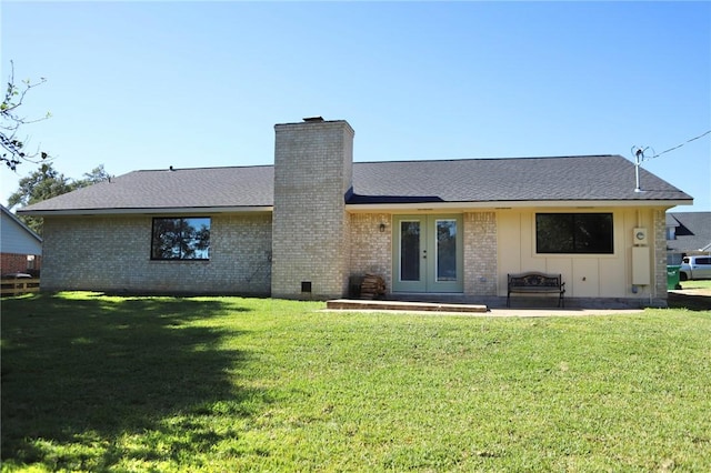 back of property with french doors, a lawn, and a patio