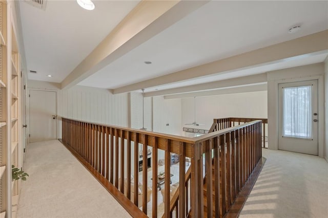 hall with light carpet and beamed ceiling