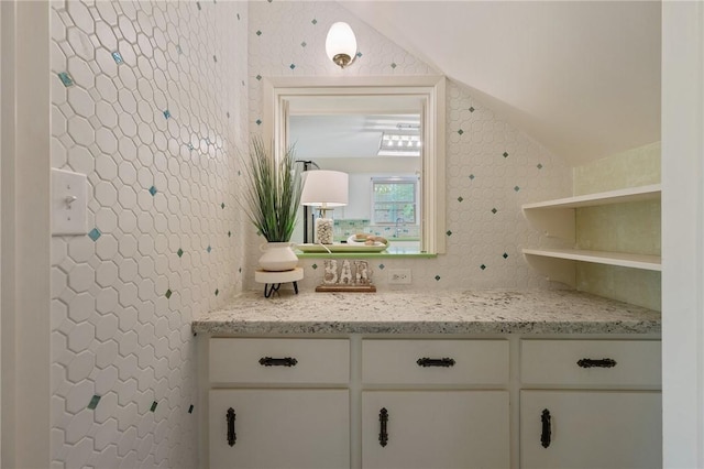 bathroom featuring vanity and lofted ceiling