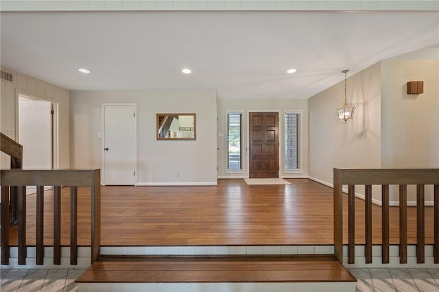 foyer featuring hardwood / wood-style flooring and an inviting chandelier