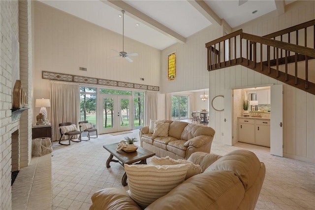 living room with ceiling fan with notable chandelier, beam ceiling, a healthy amount of sunlight, and high vaulted ceiling