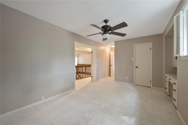 unfurnished bedroom with multiple windows, light carpet, and ceiling fan