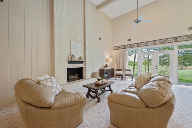 living room with ceiling fan, french doors, high vaulted ceiling, beamed ceiling, and a fireplace