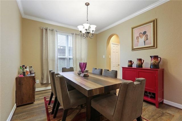 dining space featuring dark hardwood / wood-style flooring, crown molding, and a notable chandelier