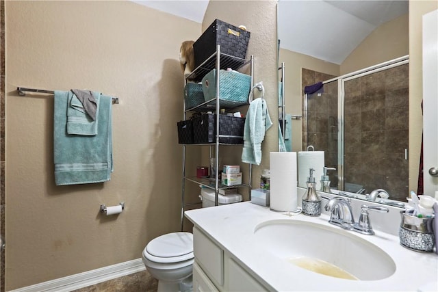 bathroom featuring vanity, a shower with door, vaulted ceiling, tile patterned flooring, and toilet