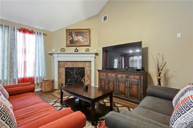 living room with wood-type flooring, lofted ceiling, and a fireplace