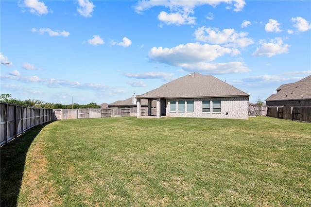 back of property with a lawn and a fenced backyard