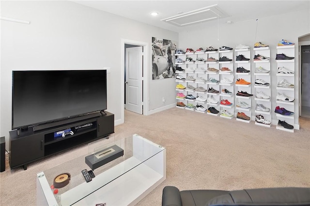 carpeted living area with attic access and baseboards