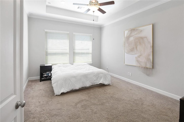 carpeted bedroom with crown molding, a raised ceiling, visible vents, ceiling fan, and baseboards