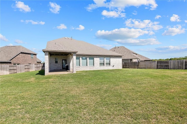 back of house with a fenced backyard, a yard, and a patio