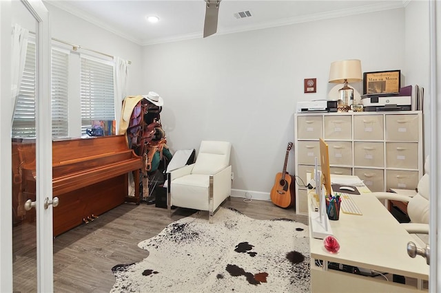 misc room with ornamental molding, wood finished floors, visible vents, and baseboards