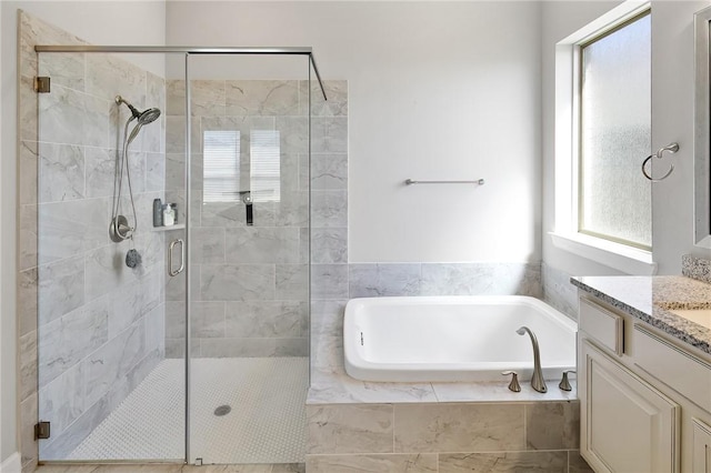 bathroom featuring a stall shower, vanity, and a bath