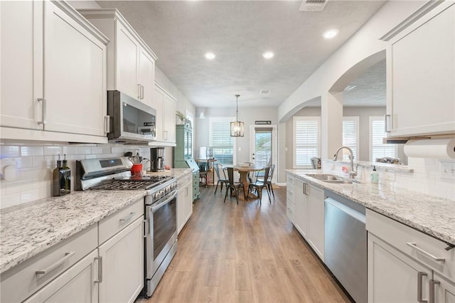 4143 Shallow Creek Loop, College Station, TX 77845 - kitchen featuring stainless steel appliances, a sink, light wood finished floors, recessed lighting, and tasteful backsplash