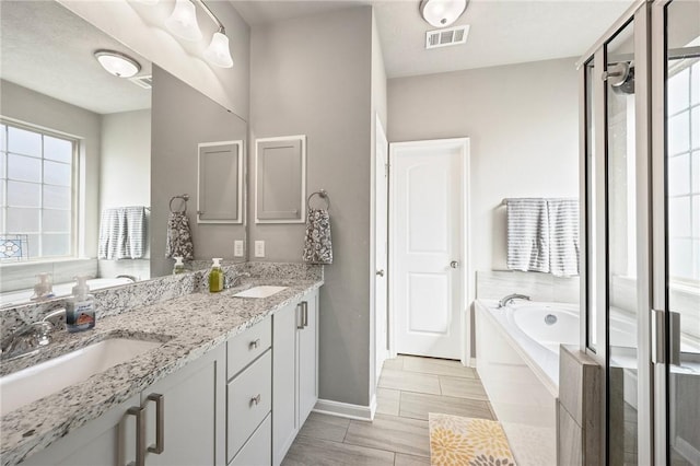 4143 Shallow Creek Loop, College Station, TX 77845 - bathroom featuring a garden tub, double vanity, baseboards, and a stall shower