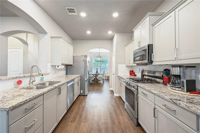 4143 Shallow Creek Loop, College Station, TX 77845 - kitchen featuring appliances with stainless steel finishes, a sink, decorative backsplash, recessed lighting, and wood finished floors