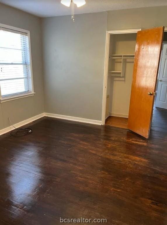 unfurnished bedroom featuring dark hardwood / wood-style flooring and a closet