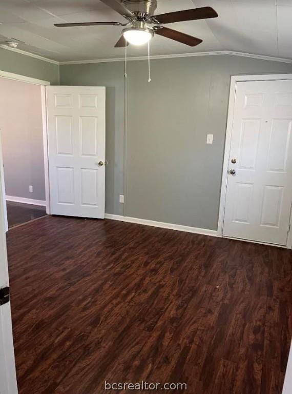 empty room featuring lofted ceiling, dark hardwood / wood-style floors, ceiling fan, and ornamental molding