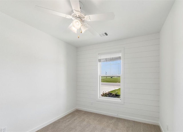 spare room featuring light colored carpet and ceiling fan