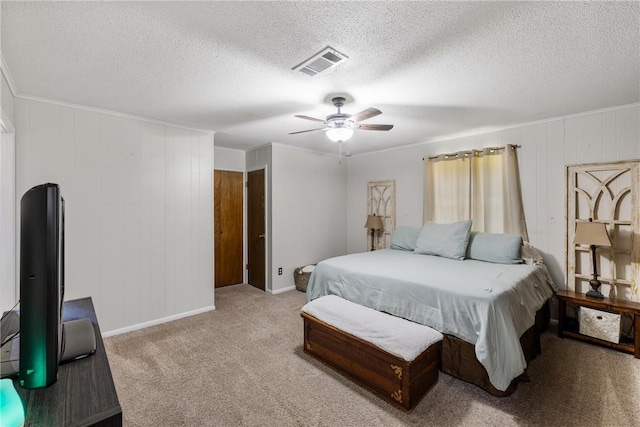 bedroom with visible vents, a ceiling fan, a textured ceiling, carpet flooring, and crown molding