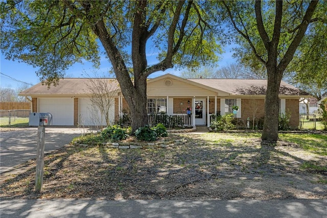 single story home with driveway, a porch, fence, a garage, and brick siding