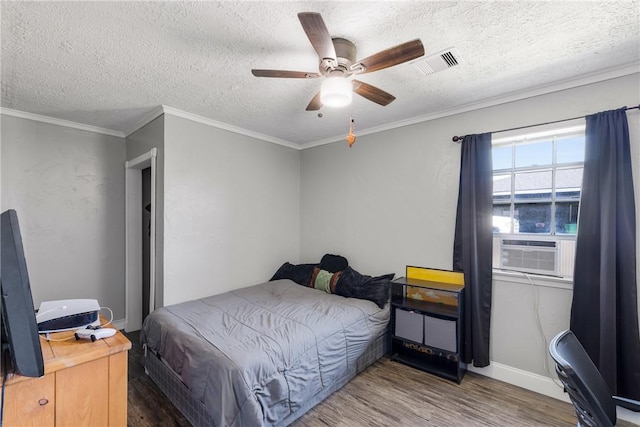 bedroom with a textured ceiling, wood finished floors, and crown molding