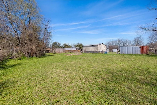 view of yard with an outbuilding and fence