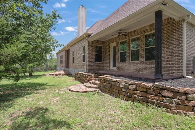 5217 Ruddy Duck Dr, College Station, TX 77845 - view of home's exterior with brick siding, a lawn, a chimney, and ceiling fan