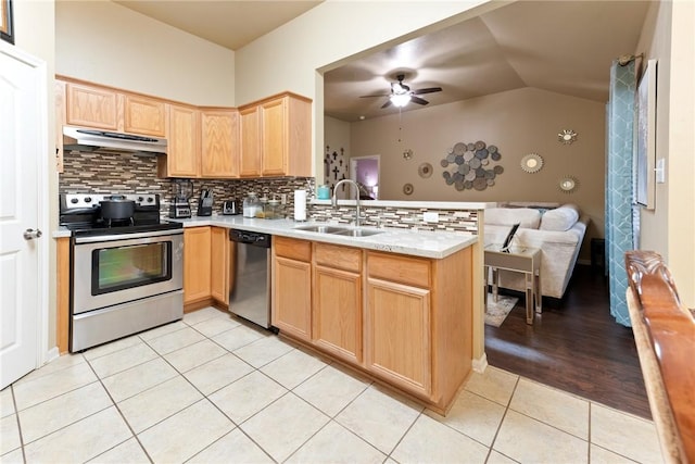 kitchen featuring sink, light tile patterned floors, appliances with stainless steel finishes, decorative backsplash, and light brown cabinets