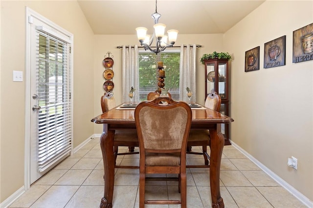 tiled dining room with lofted ceiling, plenty of natural light, and a chandelier