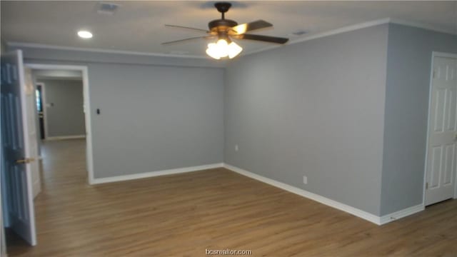 spare room featuring ceiling fan, wood-type flooring, and crown molding