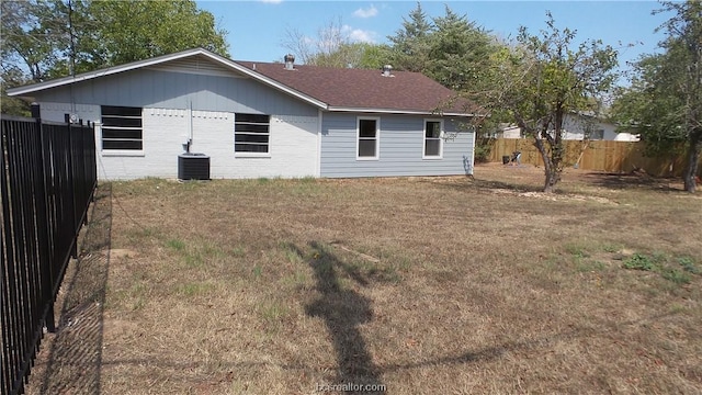 back of house with a lawn and cooling unit