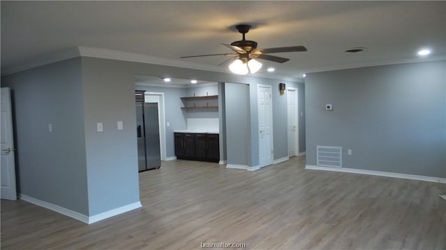 unfurnished living room with ceiling fan, ornamental molding, and light hardwood / wood-style flooring