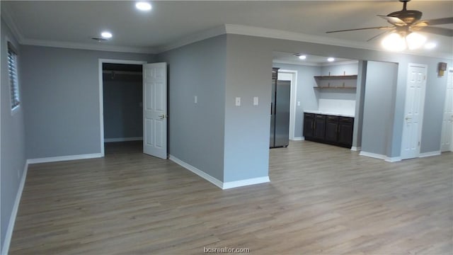 interior space featuring ceiling fan, light hardwood / wood-style floors, and crown molding