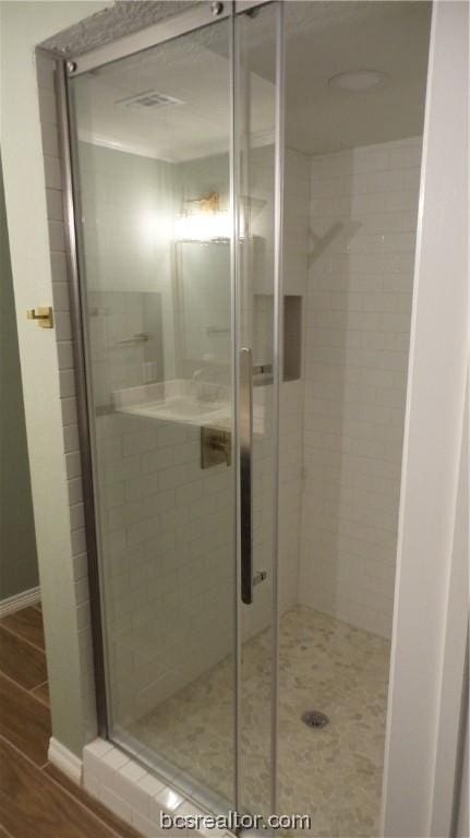 bathroom featuring wood-type flooring and a shower with door