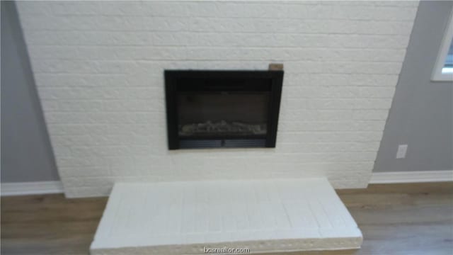 interior details featuring hardwood / wood-style floors and a brick fireplace