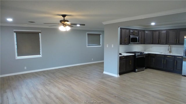 kitchen with ceiling fan, crown molding, sink, black range, and light hardwood / wood-style floors