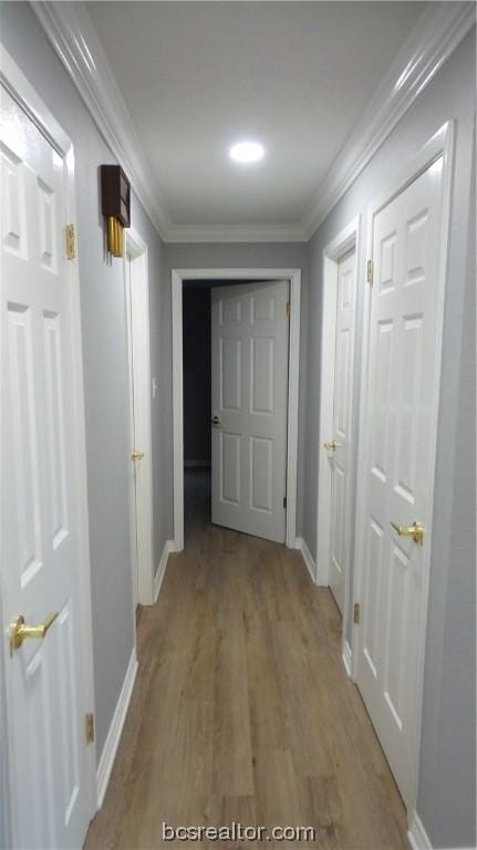 hall with light hardwood / wood-style flooring and ornamental molding