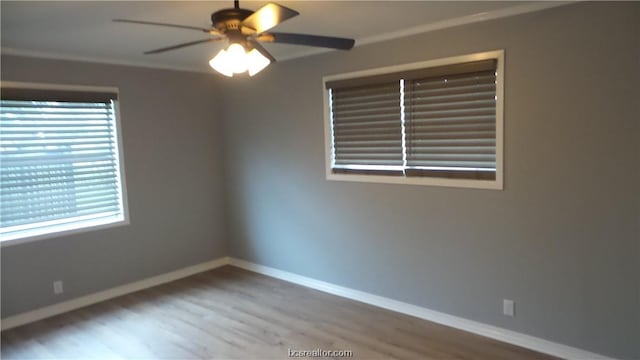 empty room featuring hardwood / wood-style floors, a wealth of natural light, ornamental molding, and ceiling fan